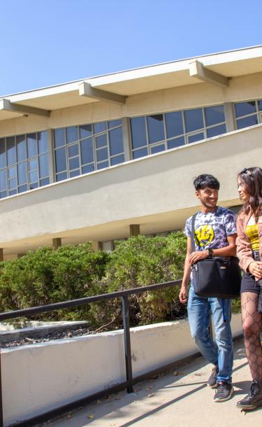 Two Students Walking Outside Building