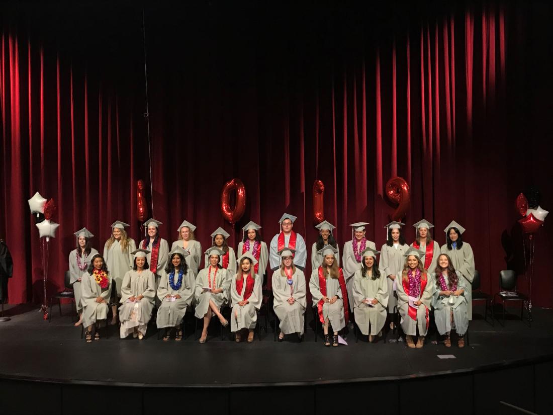 graduated people in a stage of a teather