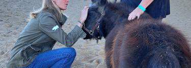 CA First Partner petting a mini horse
