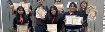 students posing with certificates